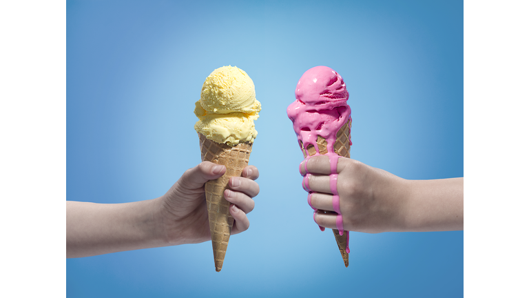 Hands holding different flavours ice cream.