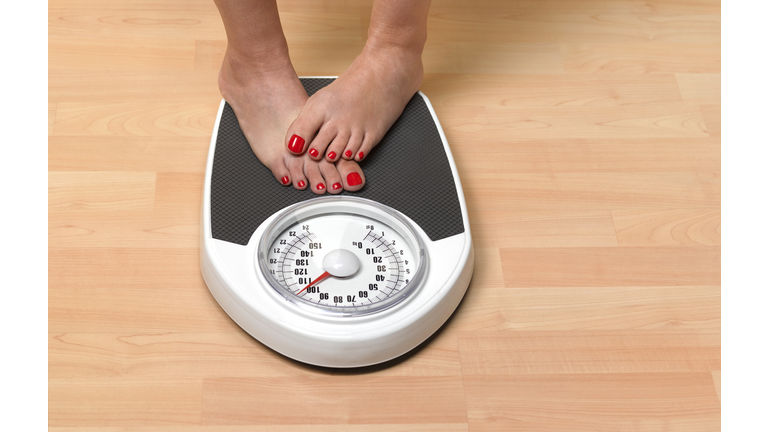 Obese woman weighing herself