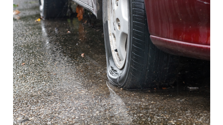 Flat tire car in rainy day on street."n