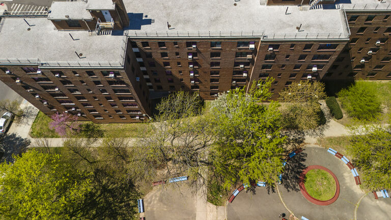 Sunny courtyard in Pomonok, NYC. Apartment complex encircled by trees in spring. Top view