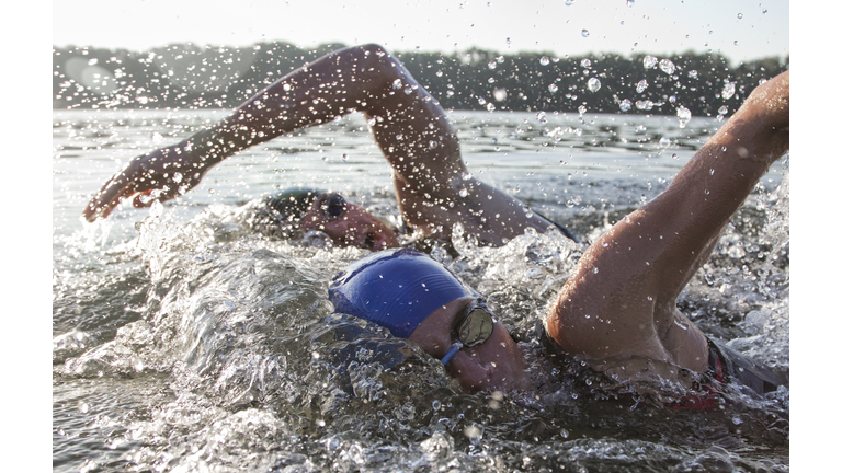 two triathletes swimming side by side