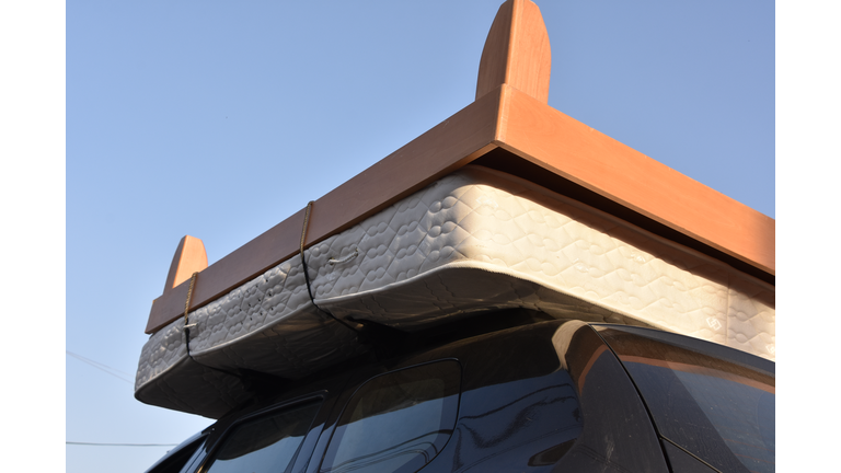 Moving a bed on the roof of a car