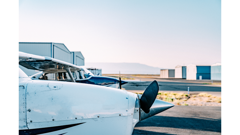 Sunrise Side-View Shot of the Front of a Small Single Engine Airplane Outdoors in Front of a Hangar