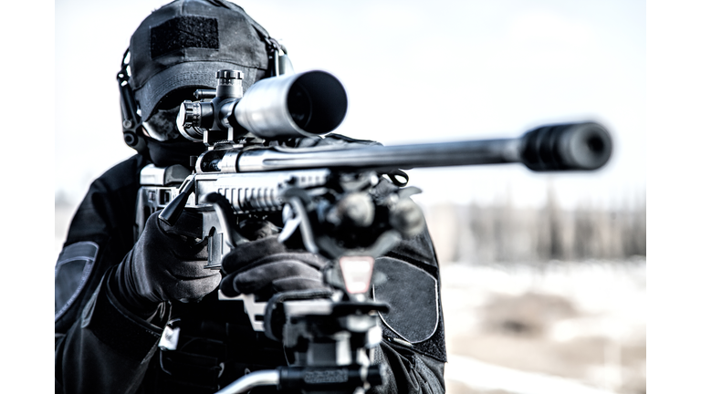 Equipped police SWAT sniper shooting with rifle