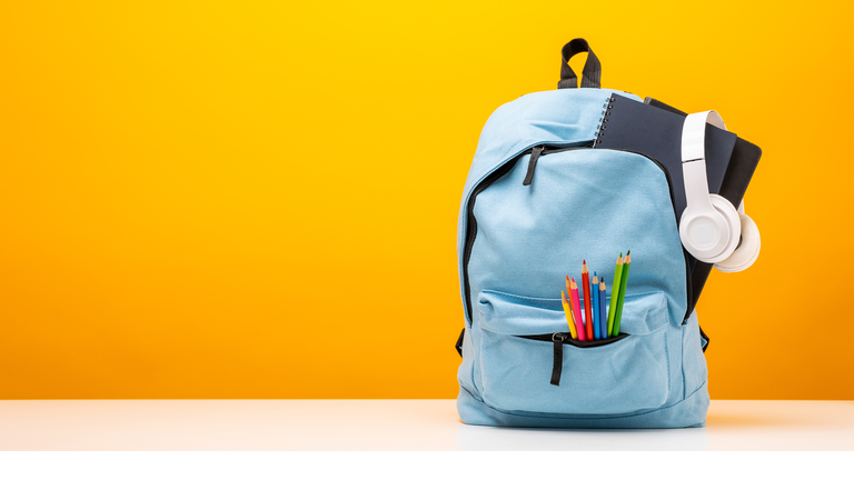 Back to school background. Stationery Supplies in the school bag. Banner design education On Yellow background.