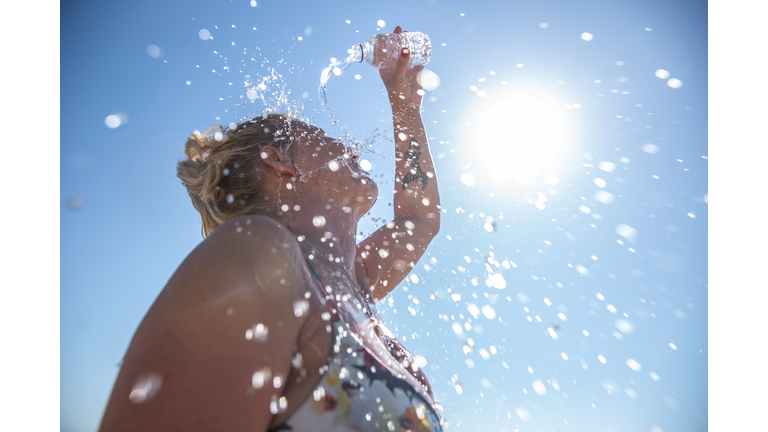 A young woman cools down with cold water during the summer heat.