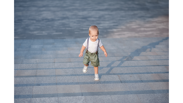 Toddler boy 1 year old learning to walk outside close up and copy space.