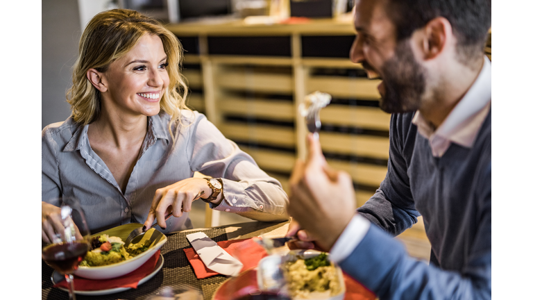 Happy business couple talking on a lunch in restaurant.