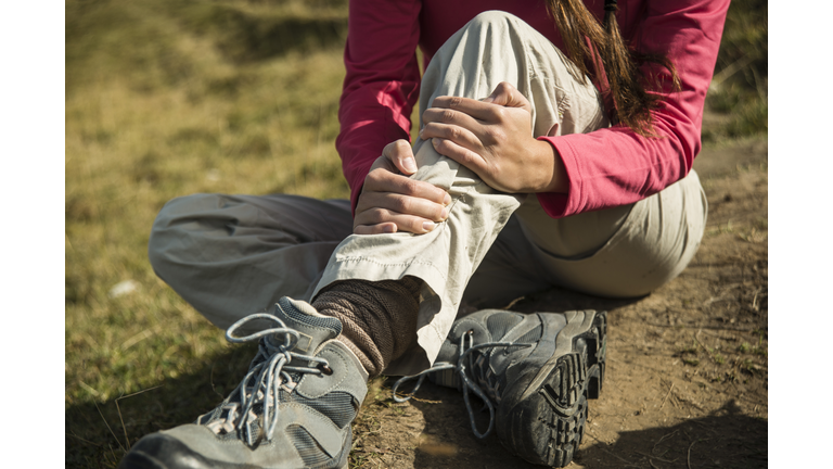 Austria, Tyrol, Tannheimer Tal, injured young woman on hiking tour