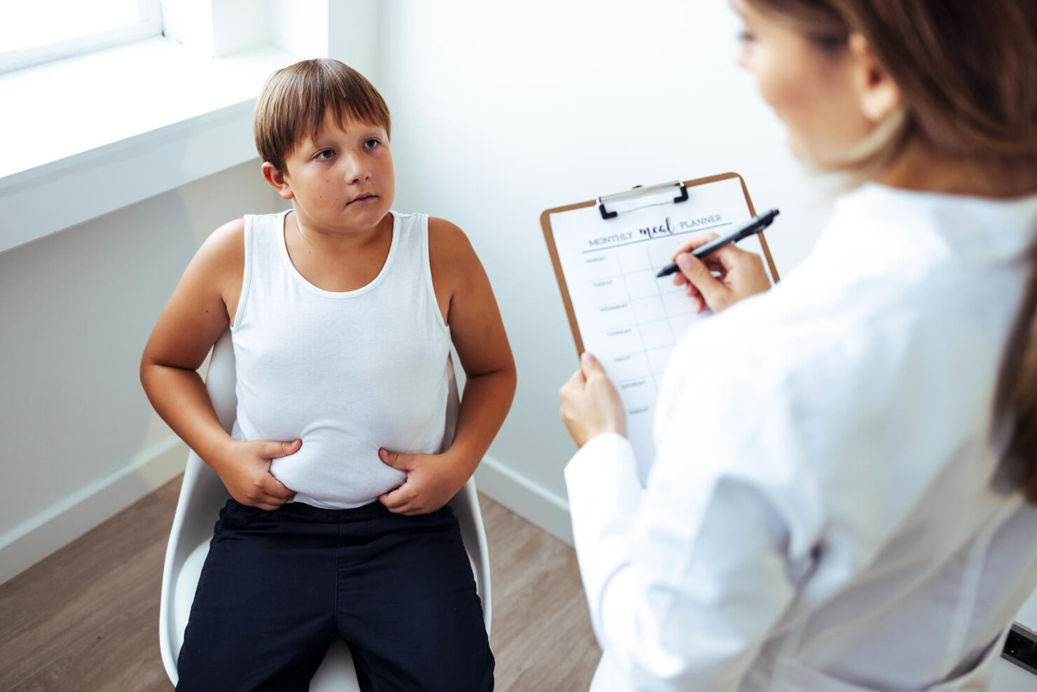 Nutritionist talking to teen obese patient