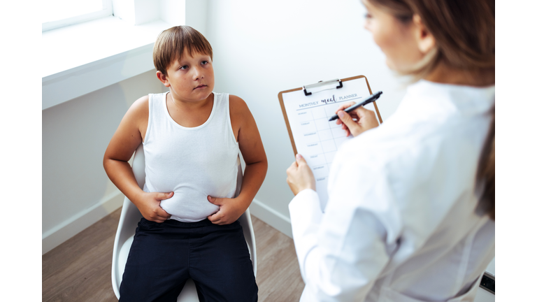 Nutritionist talking to teen obese patient