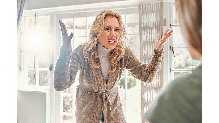 Shot of a mature woman looking upset while scolding someone at home