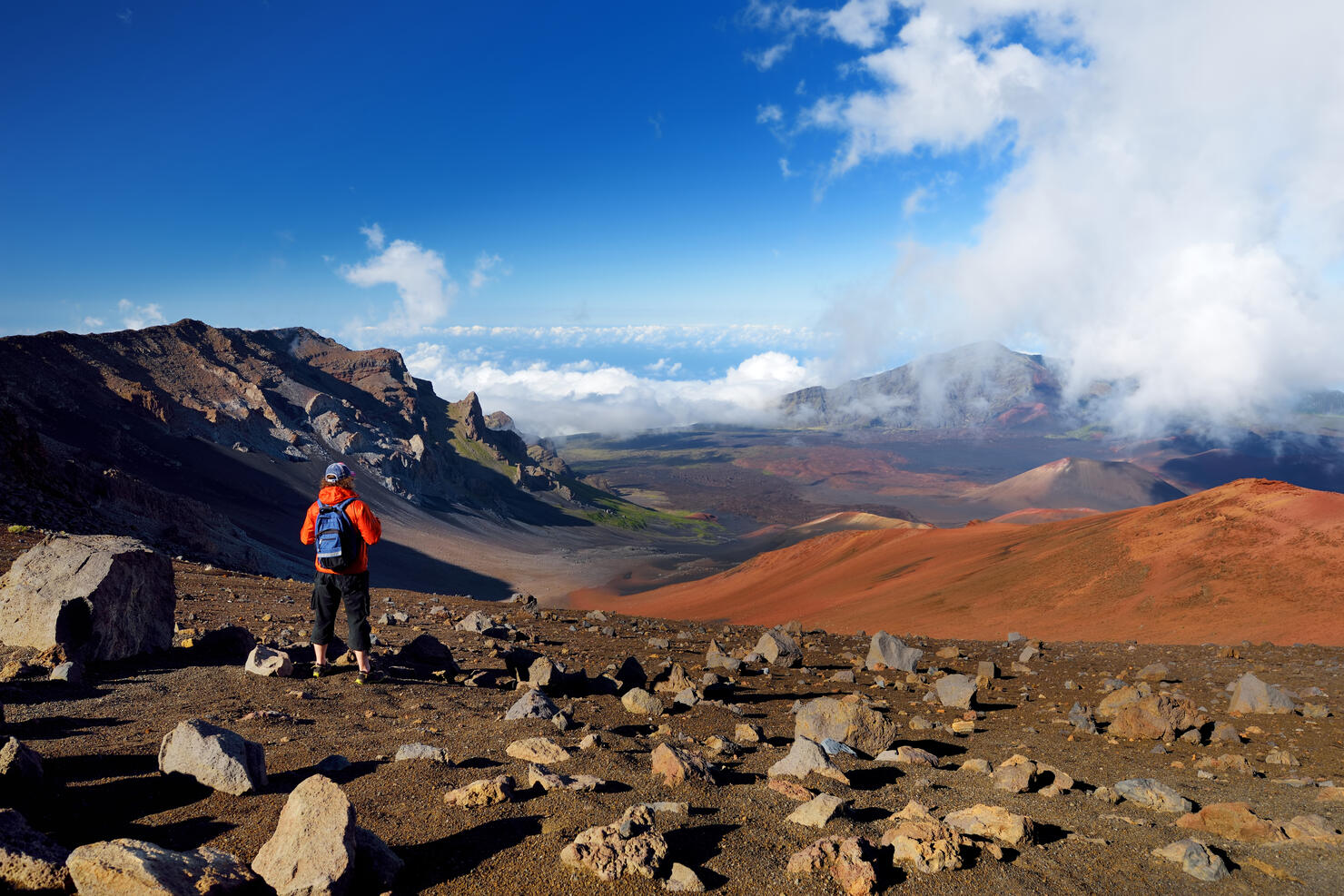 Tourist hiking in Haleakala volcano crater on the Sliding Sands trail. Beautiful view of the crater floor and the cinder cones below. Maui, Hawaii