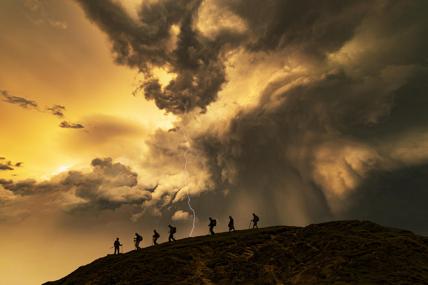 Hikers on the storm at sunset, Catbells Mountain, Lake District. UK.