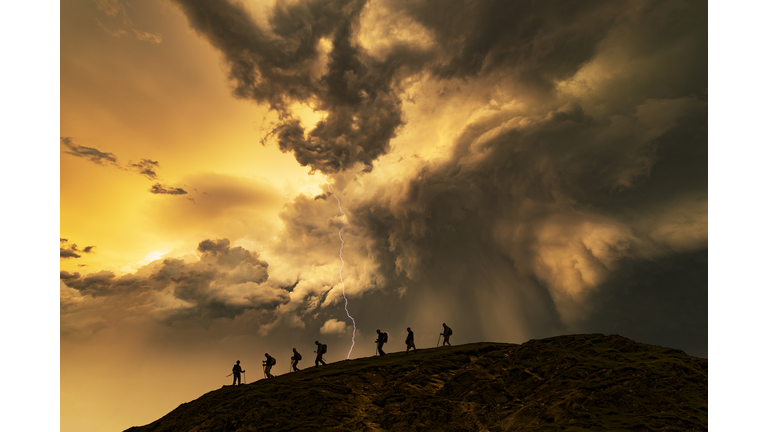 Hikers on the storm at sunset, Catbells Mountain, Lake District. UK.