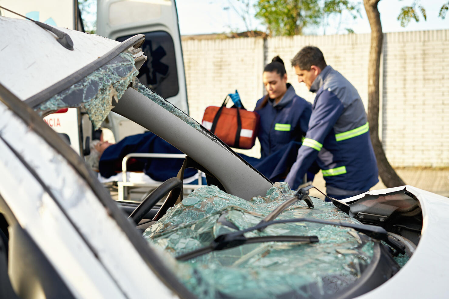 Damaged vehicle and paramedics caring for accident victim