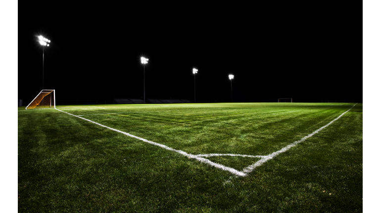 Empty soccer field at night with stadium lights on