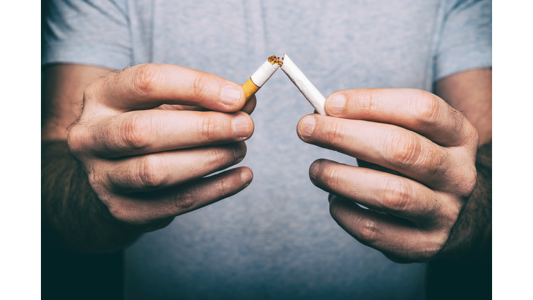 Quitting smoking - male hand crushing cigarette