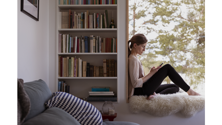 Woman at home using cell phone