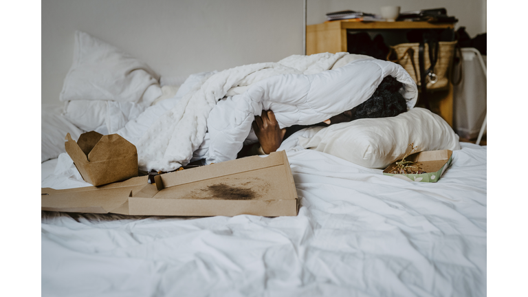 Depressed woman covered in blanket resting at home