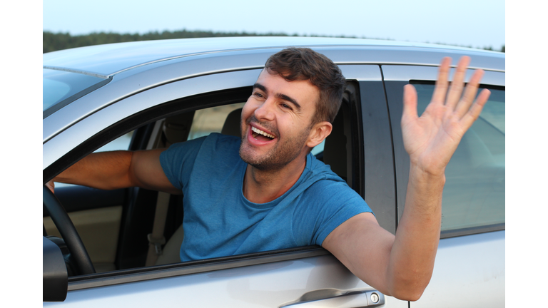 Nice man greeting someone while driving