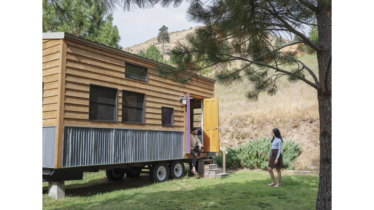 Young couple outside their tiny house