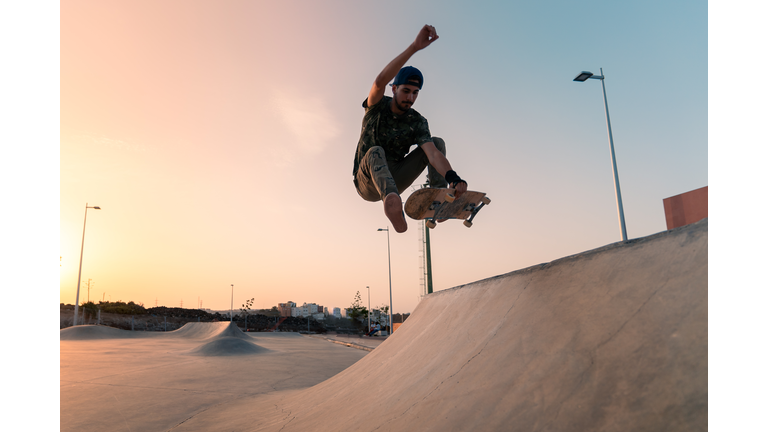 young man skates in a skate park at sunset in Gran Canaria