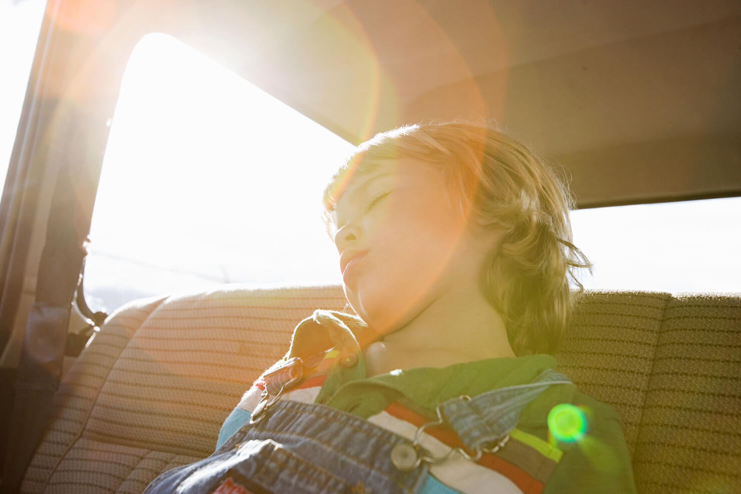 Boy asleep in back seat of car