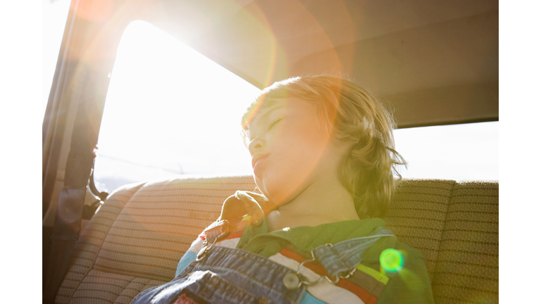 Boy asleep in back seat of car