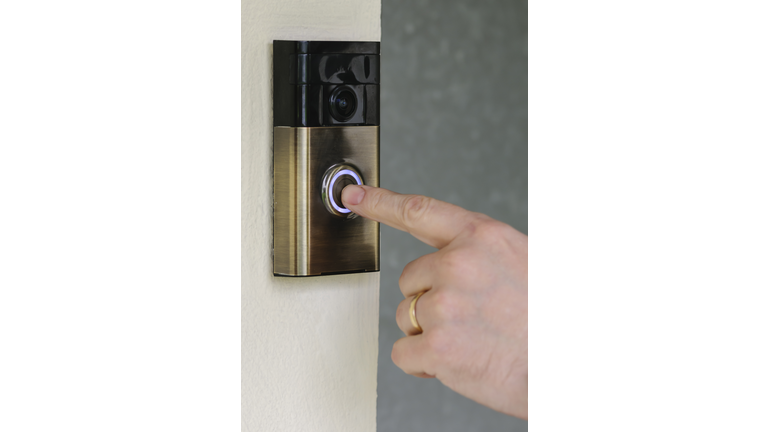 A man presses the button on a "Ring" internet video door-bell from ring.com.