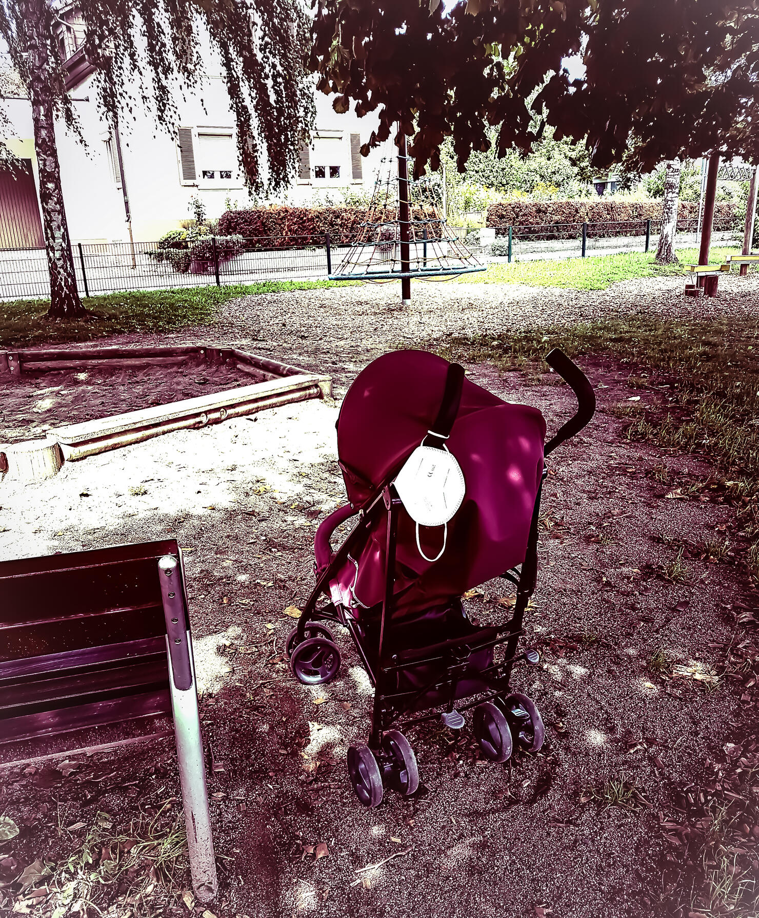 Stroller with mask stands in lockdown alone on the playground