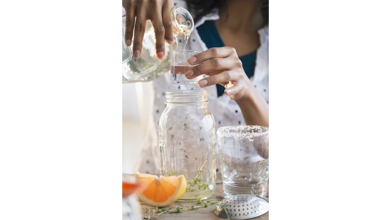 Mixed race woman making cocktail