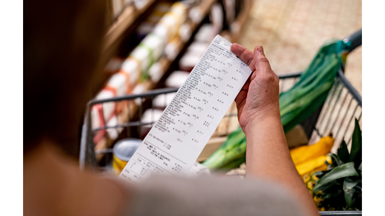 Woman looking at a receipt after shopping at the supermarket