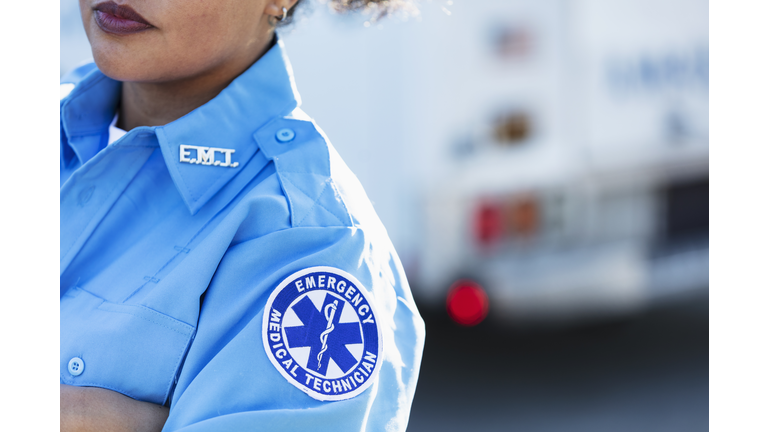 Female paramedic in front of ambulance