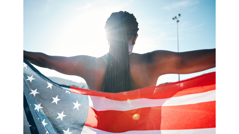 Athlete, American flag and sports with a woman outdoor at a stadium to celebrate country, pride and win. Back of a person for olympic sport, fitness and exercise achievement at competition in USA