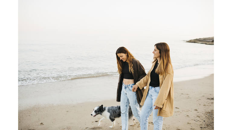 Two woman at the beach with a dog