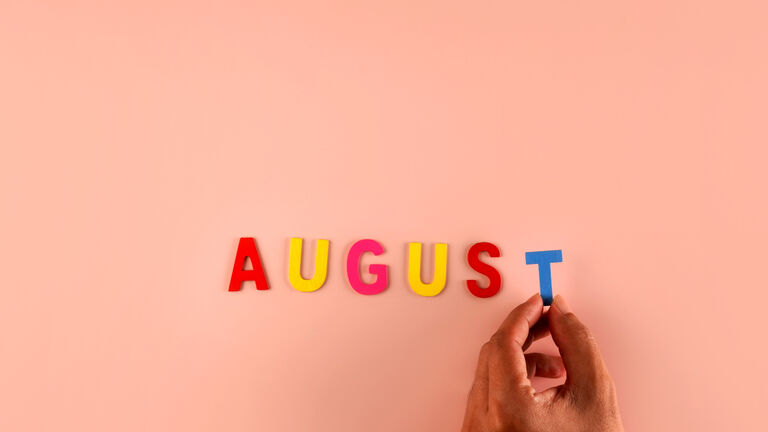 Hand holding , August  word block in pink background