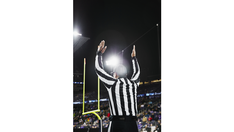 Referee signaling touchdown on field during game