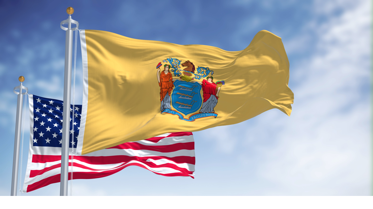 The New Jersey state flag waving along with the national flag of the United States of America