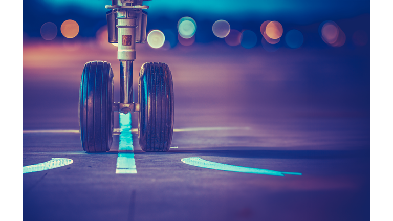 Airplane Wheels On The Runway At Sunset