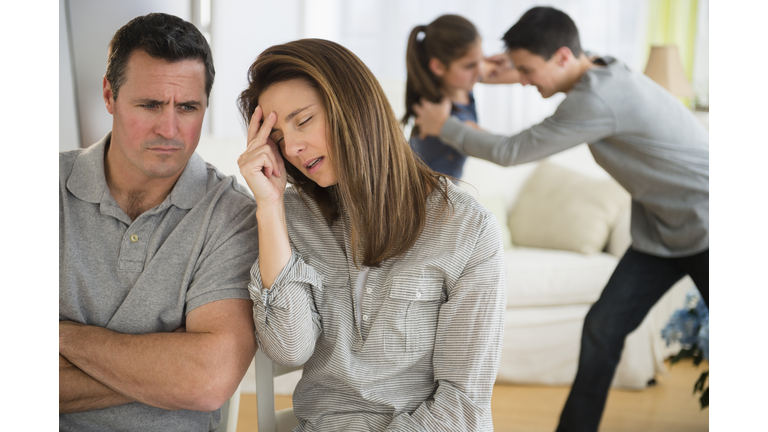 Frustrated Caucasian parents listening to children fight