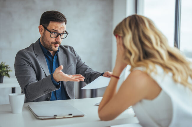 Manager is hard talking with employee in an office.