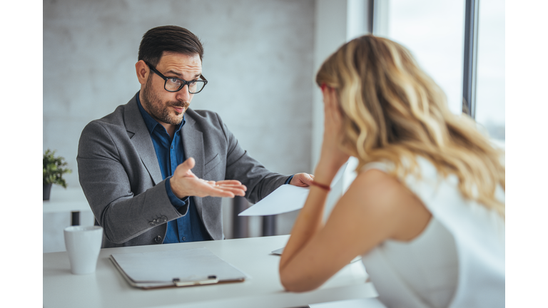 Manager is hard talking with employee in an office.