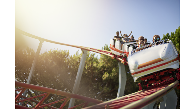 Kids having fun in amusement park roller coaster during COVID-19 pandemic
