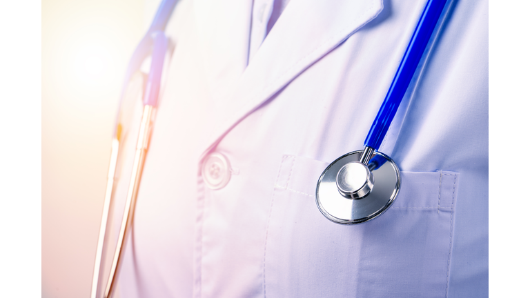 Female doctor portrait, young woman physician holding a stethoscope isolated on white background, close up, cropped view, copy space