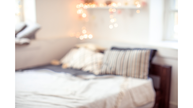 blurred bedroom background with bed window and lights