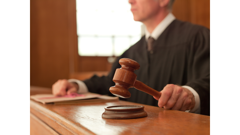 Judge holding gavel in courtroom