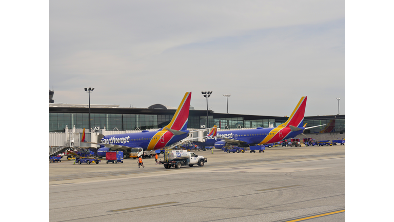 Two Southwest Airlines aircraft loads passengers and cargo at the Will Rogers World Airport.