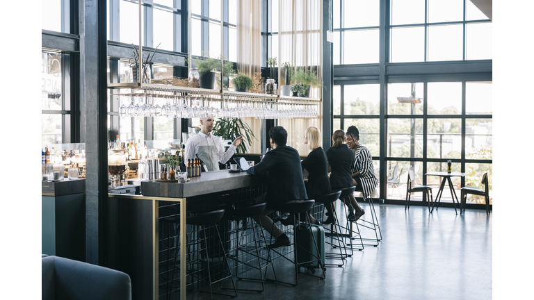 People sitting behind the bar counter