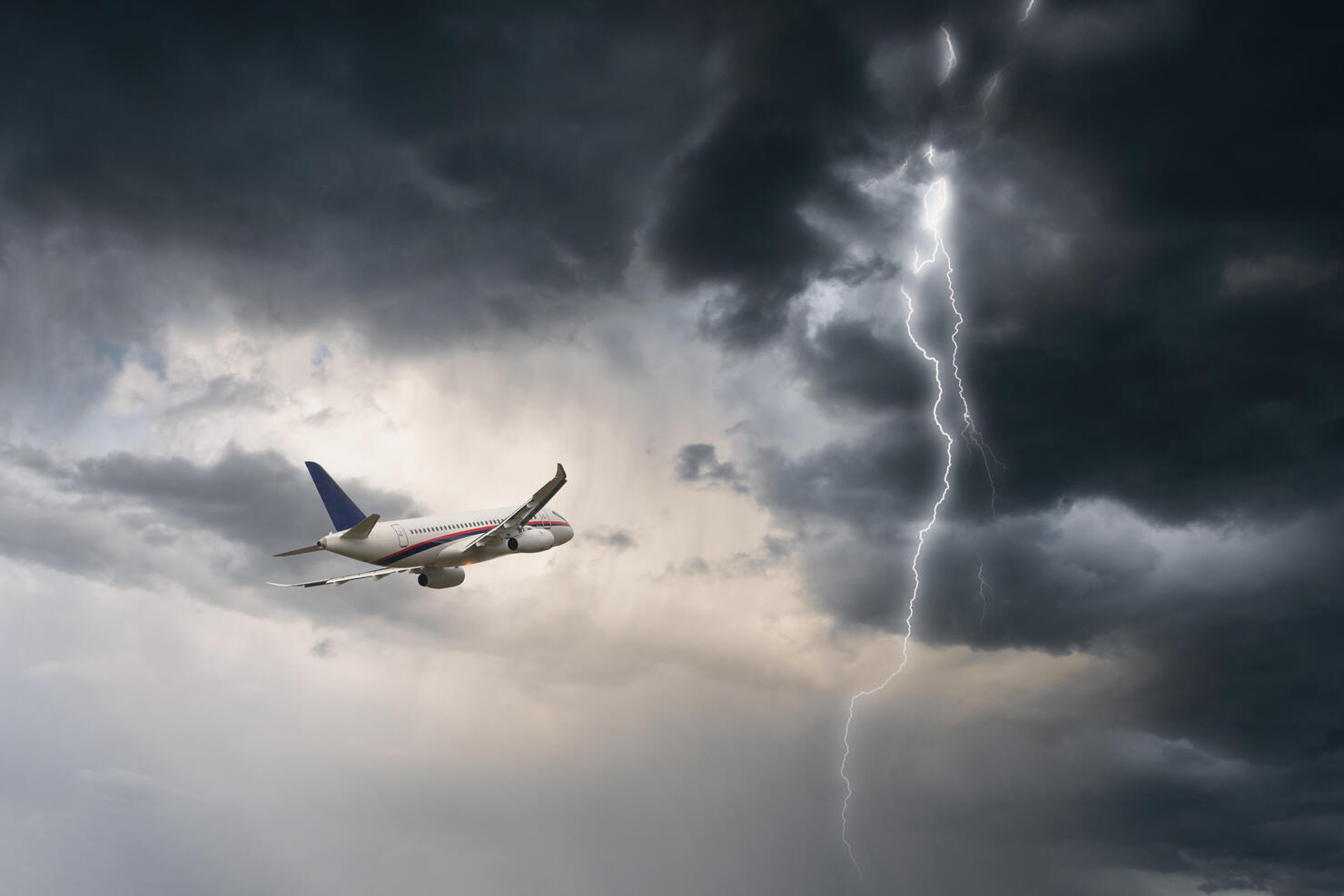 Commercial airplane flying in stormy weather with a lightning - dangerous flight and risk of aircraft accident